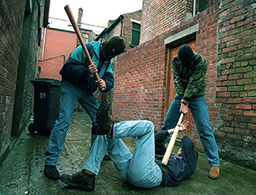 This is a photograph of two masked men hitting another man with baseball bats.