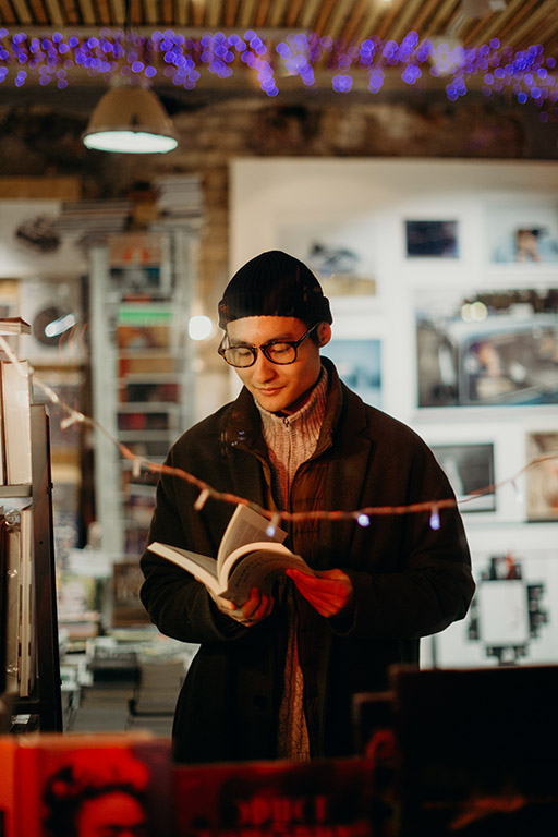 This image shows a person in a bookshop reading a book.