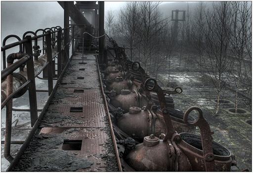 An image of a rusty, disused industrial equipment in a bleak winter landscape.