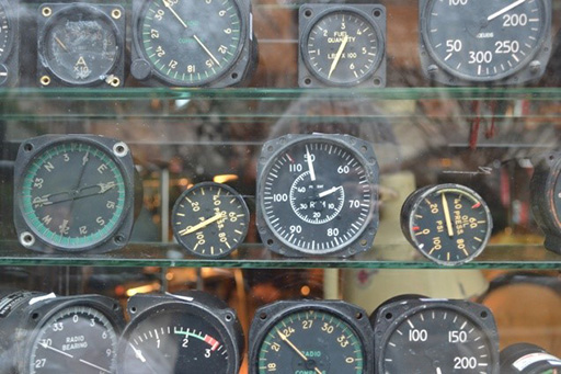 An image of some dials of different sizes on glass shelves.