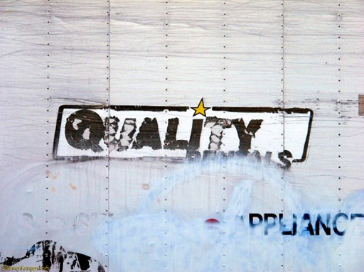 An image of a painted sign reading ‘quality’.