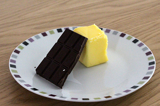 An image of a block of butter and a slab of chocolate on a plate.