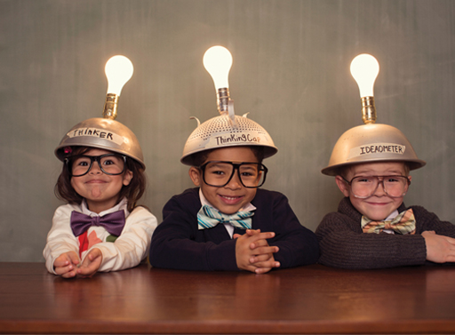 A photograph of three children, with light bulbs above their heads.