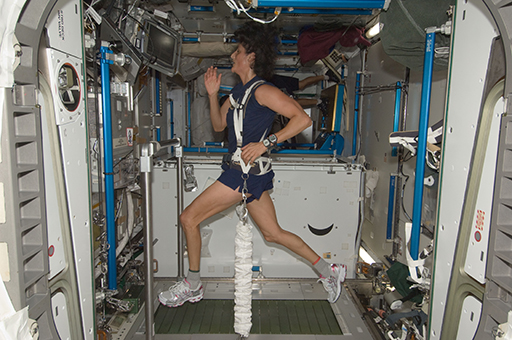 A colour photograph of an astronaut using a treadmill.
