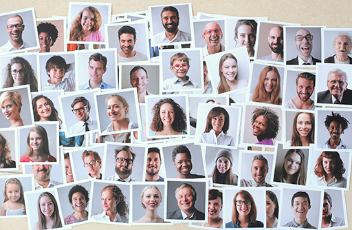 Approximately 50 overlapping passport photos of people of different ages, genders and ethnicity