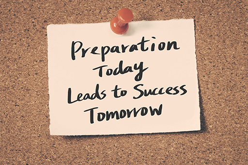 A note is pinned to a cork noticeboard. It reads ‘Preparation today leads to success tomorrow’.