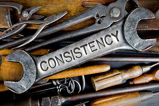 In the centre of a pile of tools is a spanner with the word ‘consistency’ written on it.