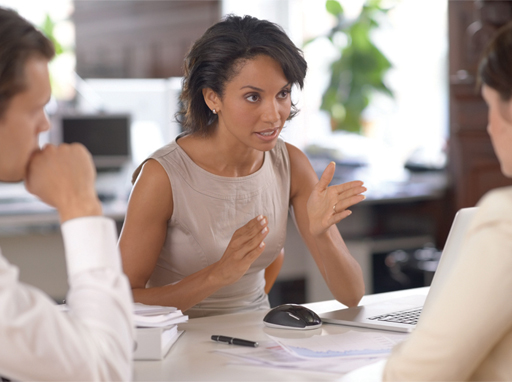 A photograph of a woman talking and gesturing with her hands.