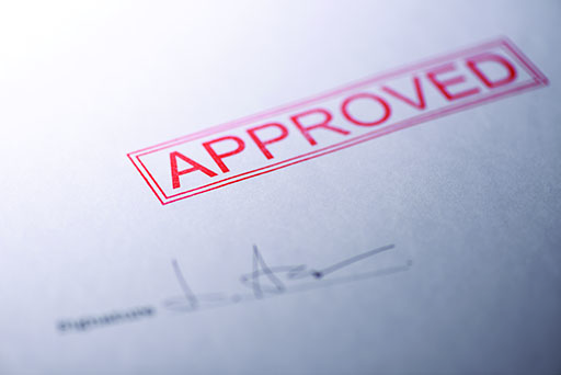 An image of a piece of paper with ‘Approved’ stamped on it.