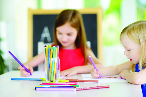 A photograph of two children drawing.