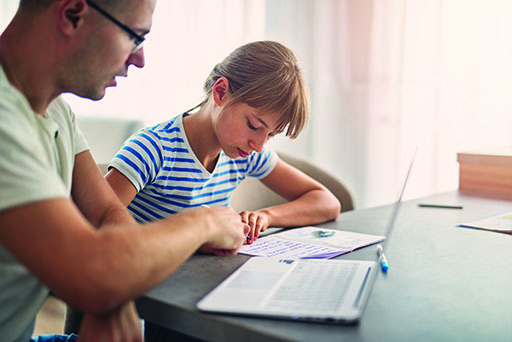 A photograph of a man helping a girl with homework