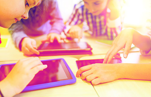 A group of children using tablets.