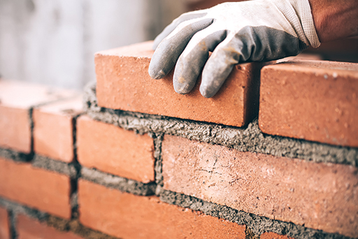 A photo of a red brick wall being built