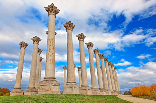 An image of free standing Roman columns standing against a blue sky