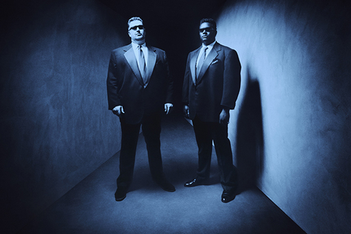 An image of two bouncers in suits standing in a corridor