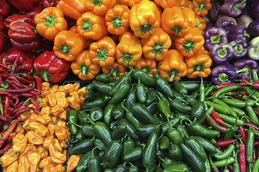 A very colourful image of piles of different peppers