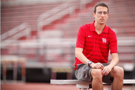 Photo of Steve Magness sitting on a bench in what looks to be an athletics stadium.