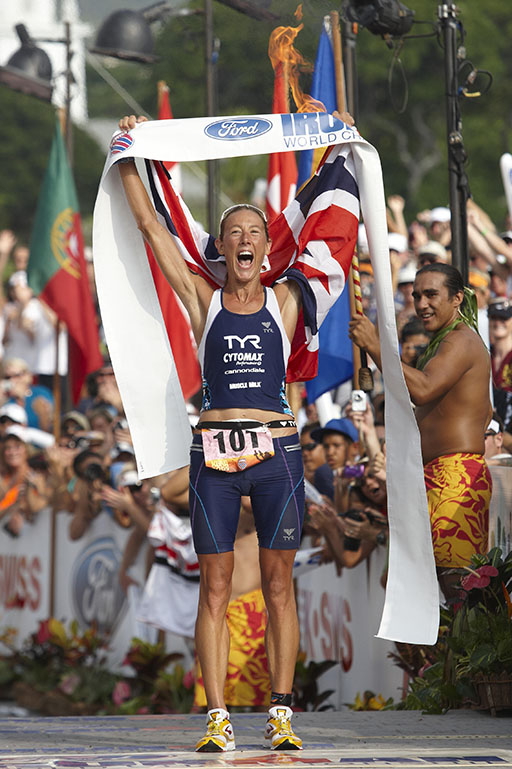 A full-length photograph of Chrissie Wellington, triumphant at the World Ironman Championships.