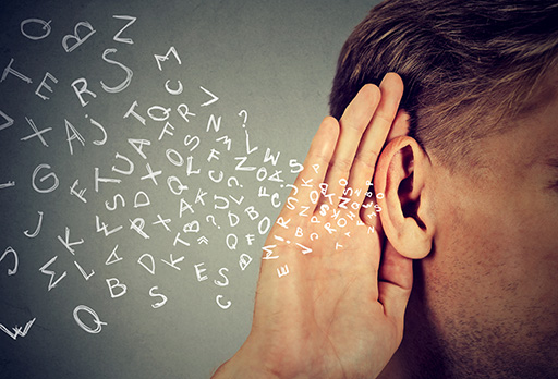 A man cups his ear as a stream of white letters flow in.