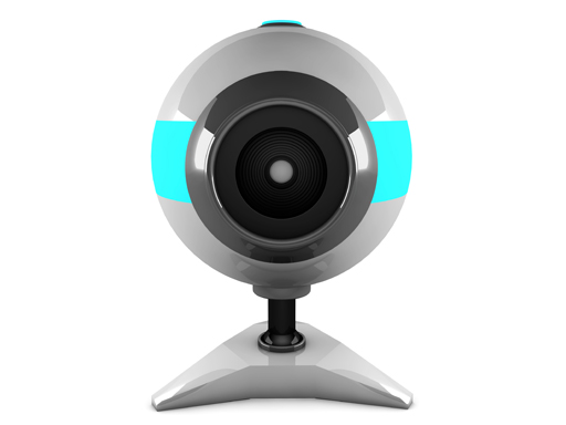 A silver webcam against a white background is facing directly towards the camera.