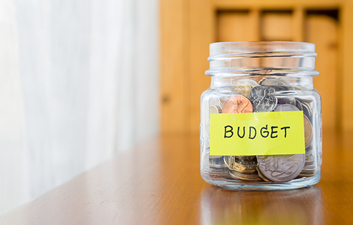 Photo of a jar containing money. The jar is labelled ‘Budget’.