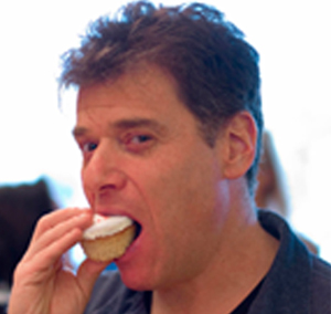 A picture of Andrew Keen eating a cake.