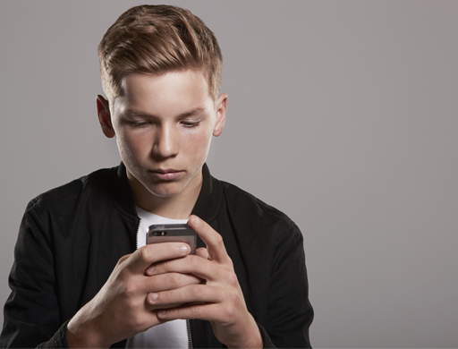 A young man is paying careful attention to his mobile phone.