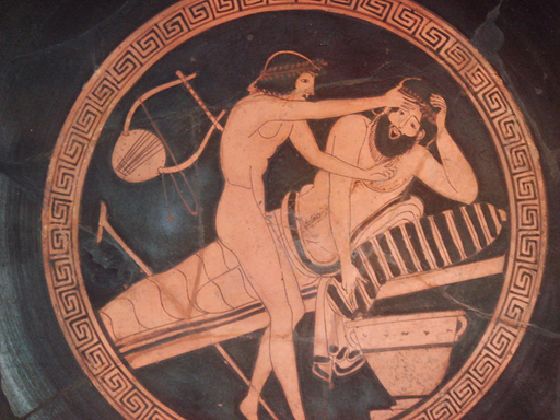 Decoration on the base of a ceramic dish, depicting a drunken man lying on a couch, vomiting while a young slave holds his forehead.