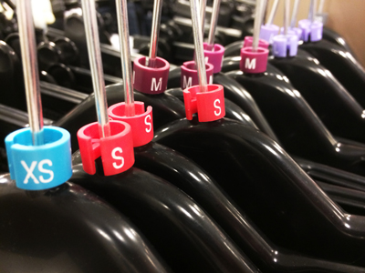 Clothes hangers showing sizes: XS, S, M.