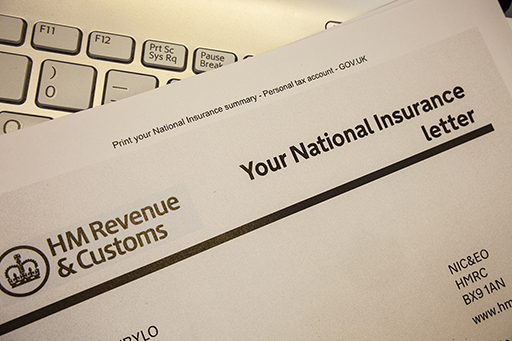 The image is the top of a letter from HMRC concerning National Insurance. The letter is lying the keyboard of a computer.