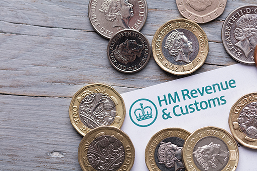 The image is a collection of British coins placed on top of a letter from HMRC.
