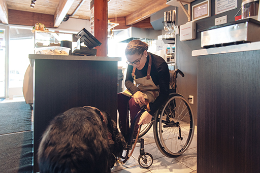 This is a photograph of a person in a wheelchair with a dog.