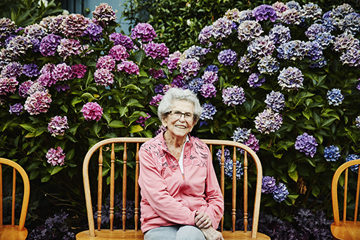 This is a photograph of a woman sitting in a garden.