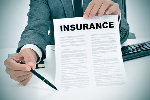 The figure is a photo of a man holding an insurance contract up in front. The man holds a pen pointing to the place where the contract has to be signed.