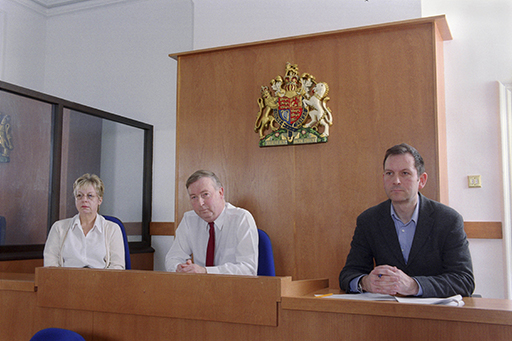 This is a photograph of three magistrates sitting in a court room.