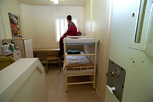 This is a photograph of a child in a prison cell.