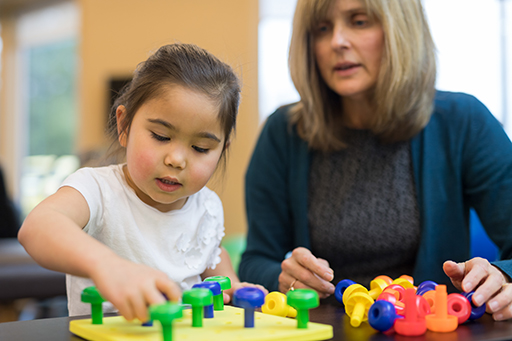This is a photograph of a woman playing a game with a young girl.