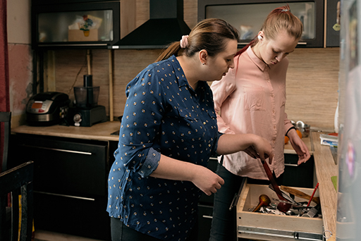 This is a photograph of two women in a kitchen.