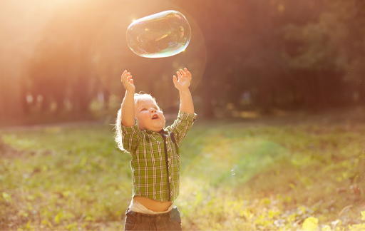 This is a photograph of a child chasing a bubble.
