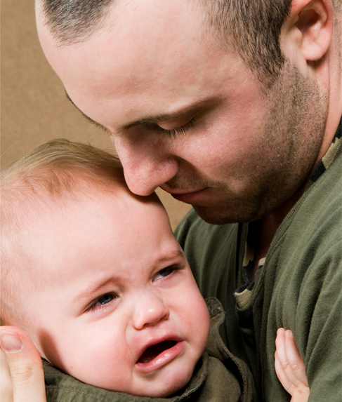 This is a photograph of a man holding a crying baby.