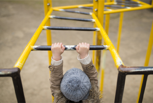 This is a photograph of a child playing on the monkey bars.