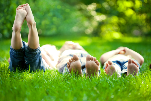 This is a photograph of three children laying in the grass.