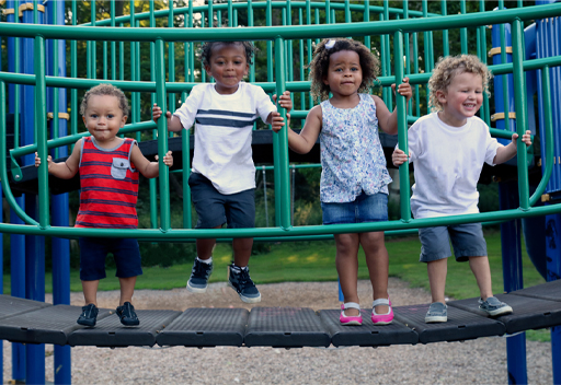 This is a photograph of four children on some play equipment.