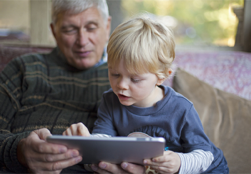 This is a photograph of an adult and a child using a tablet.