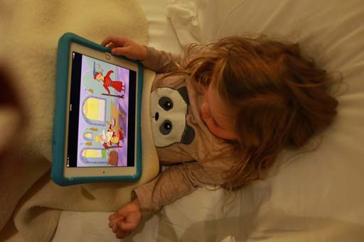 This is a photograph of a child using a tablet.