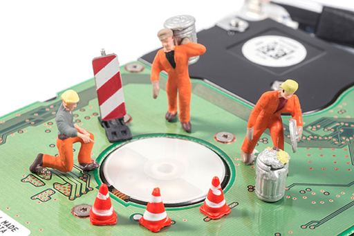 This shows three figurines dressed as builders on top of a computer.