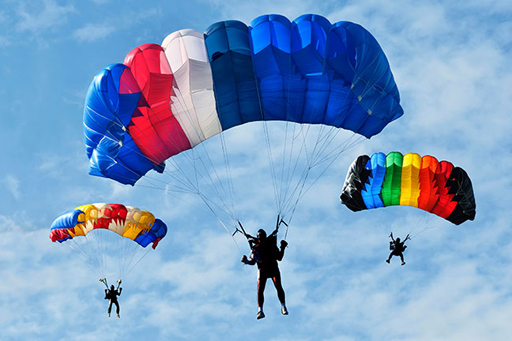 This photograph shows three people sky diving.