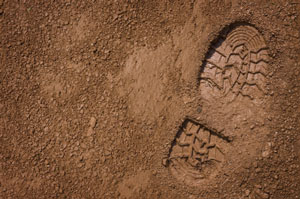 Image of a very clear shoe print in the sand.
