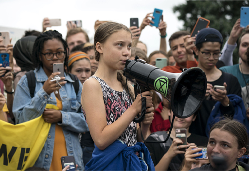 Greta Thunberg, a young environmental activist, talking to a crowd of people.