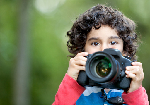 An image of a child holding up a camera.
